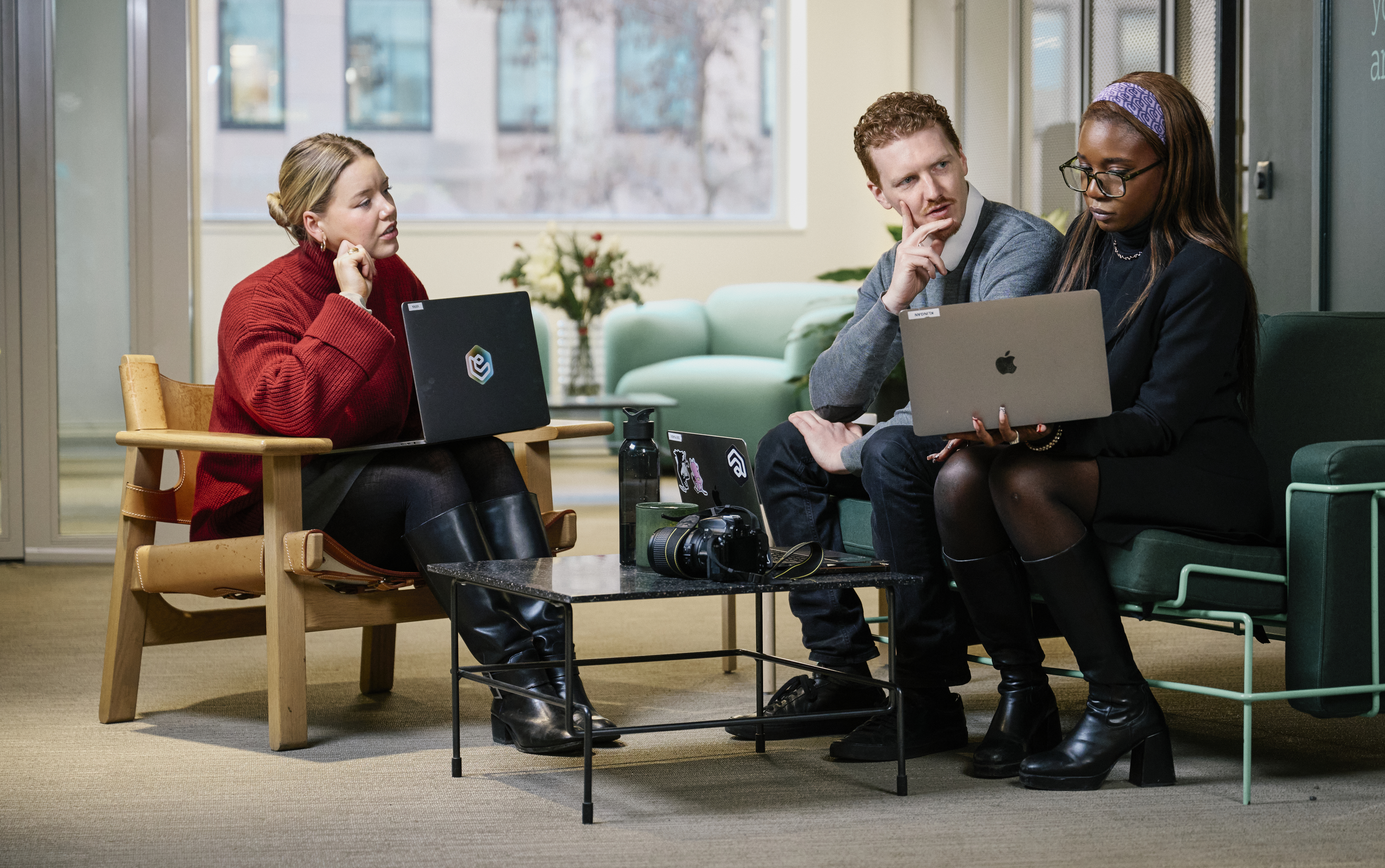 An office environment where employees work on laptops.